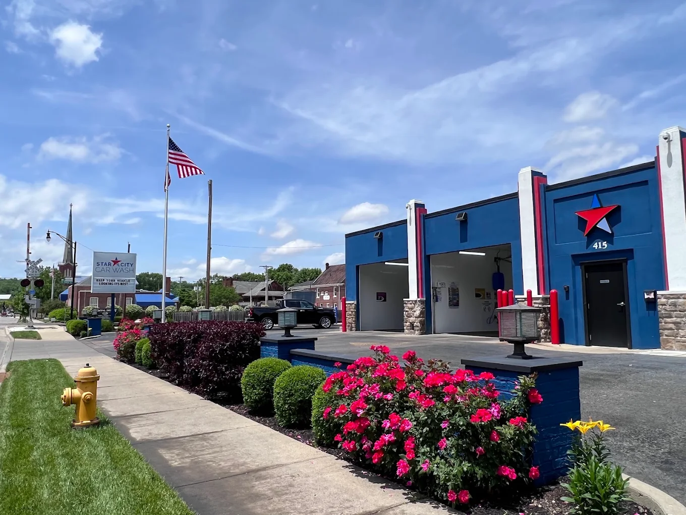 Star City Car Wash’s blue building and red star, with flowers outside the wash bays